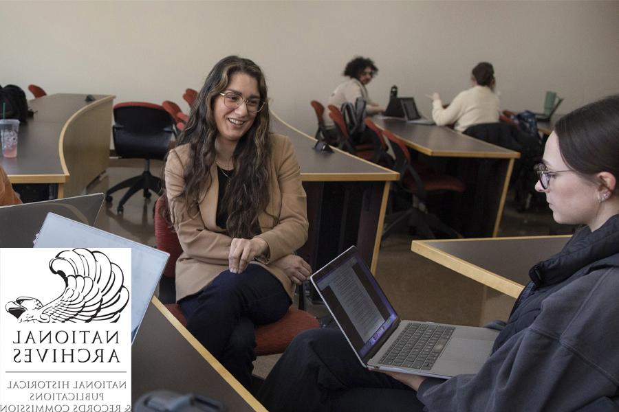 Yesenia Cervera sits with students in a classroom.