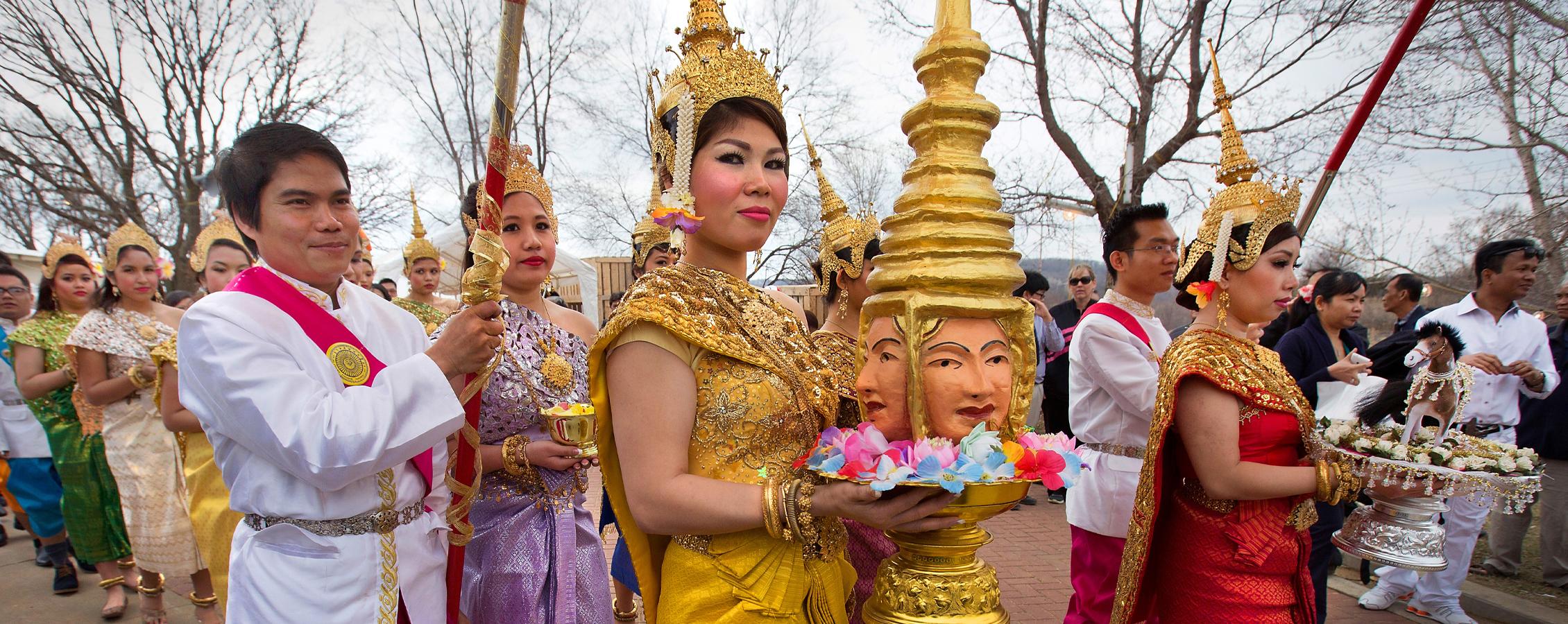 A woman dressed in gold is part of a procession during during Khmer New Year celebration in Southeast Asia.