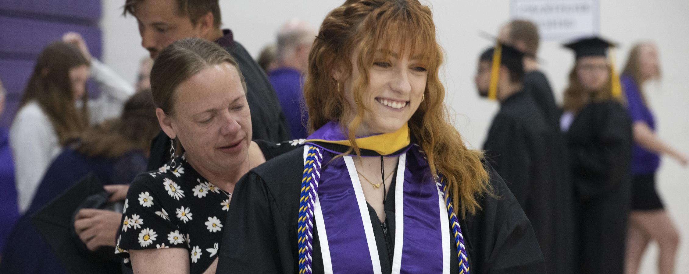 A social work student smiles at Commencement.