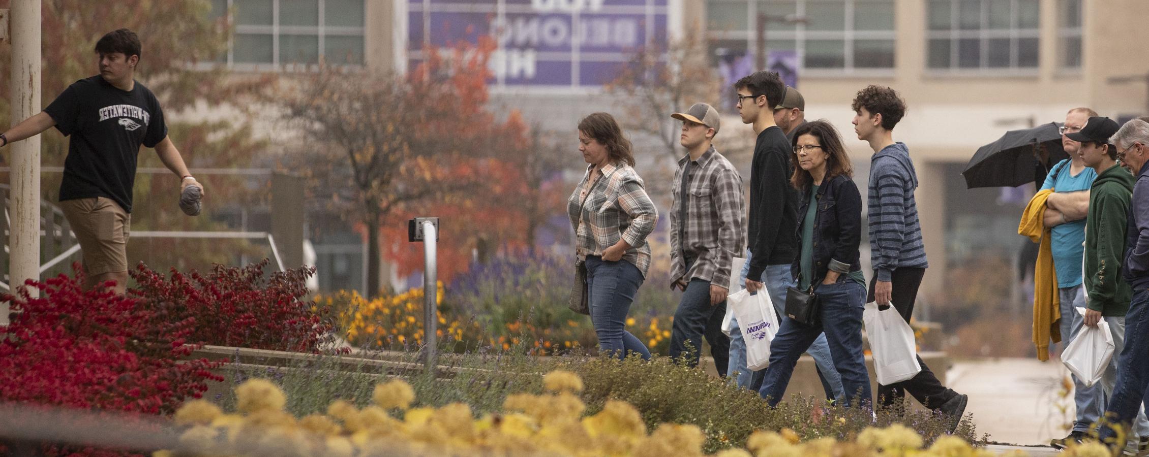 A group of people touring campus are about to enter McGraw Hall.