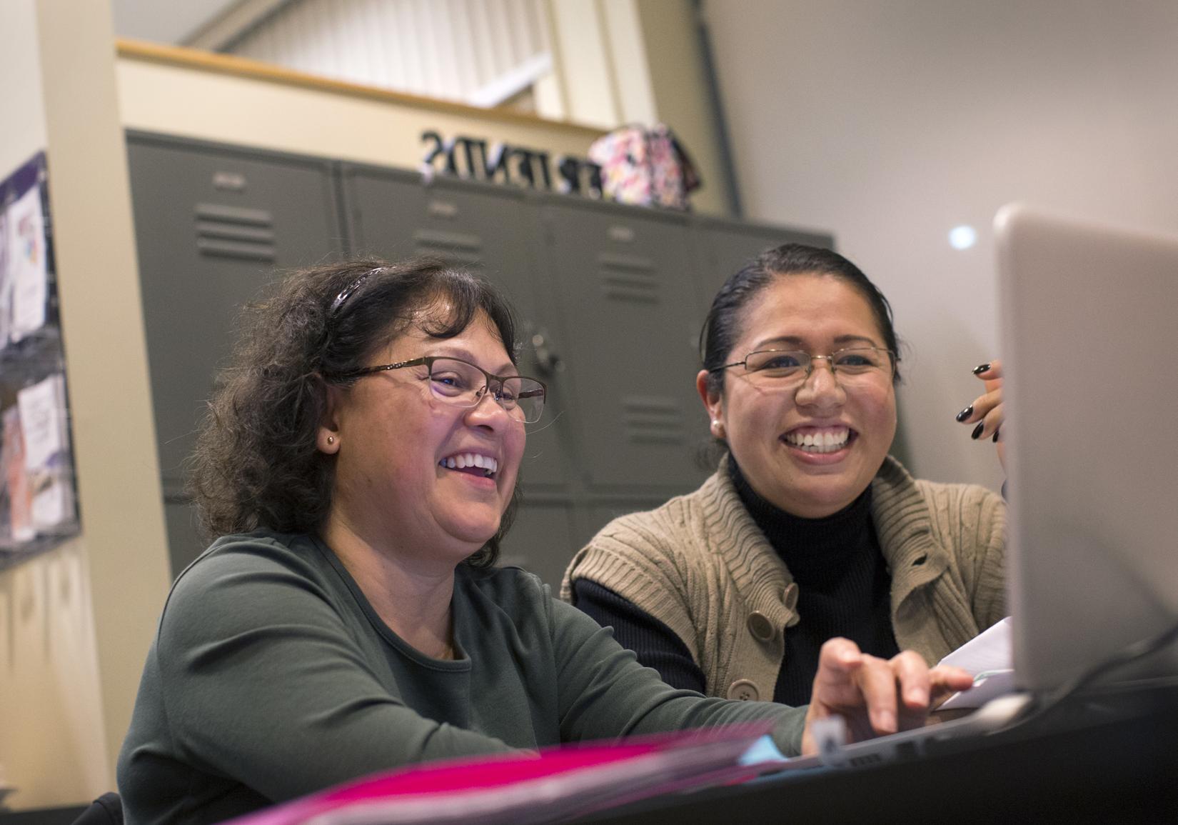 Rocio Aburto and Adelaida Sisk smiling and looking at a laptop screen