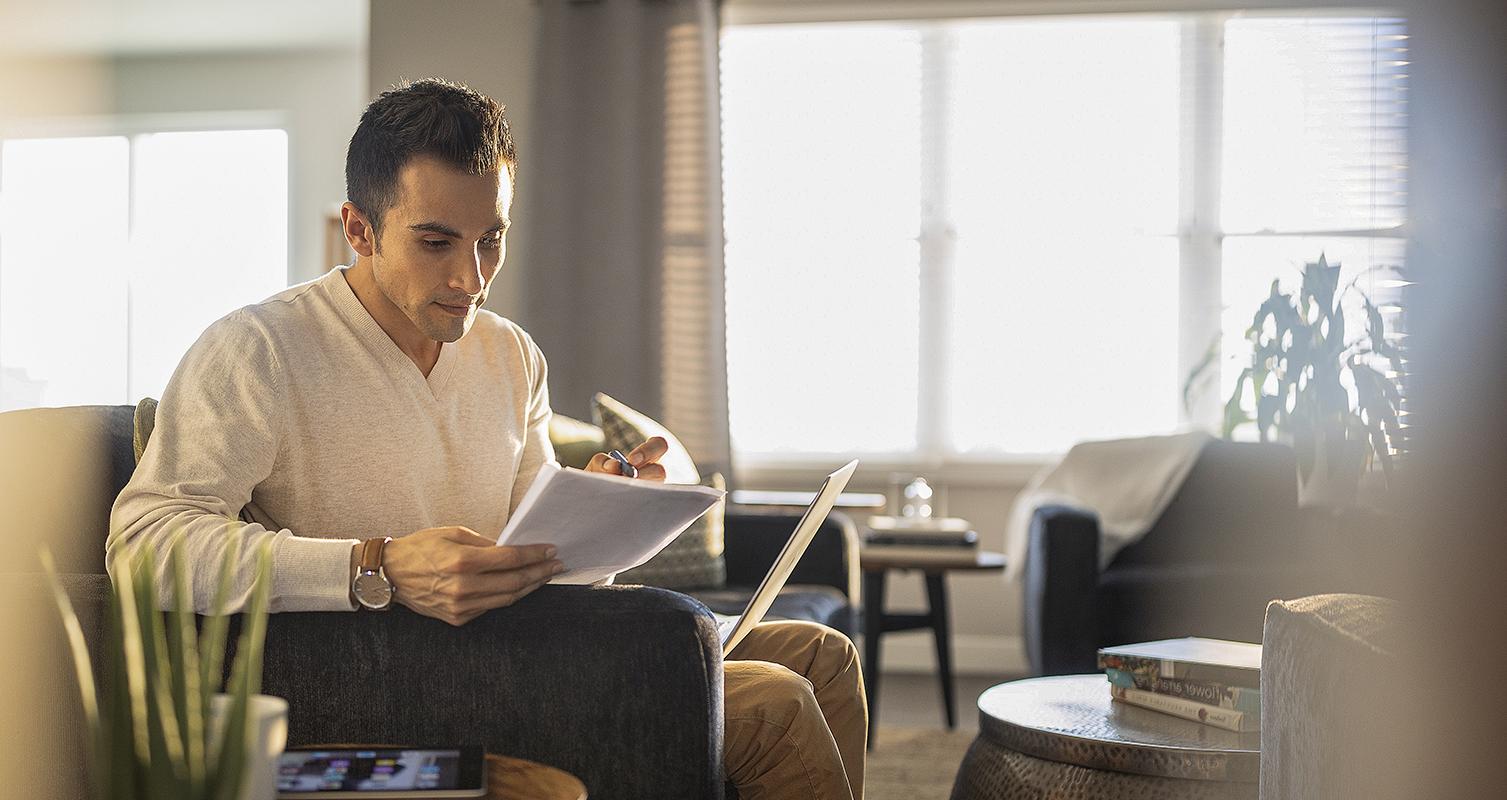 Man studying at home with laptop and tablet