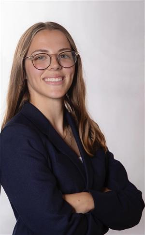 white woman in early twenties with long light brown hair and dark eyes smiling