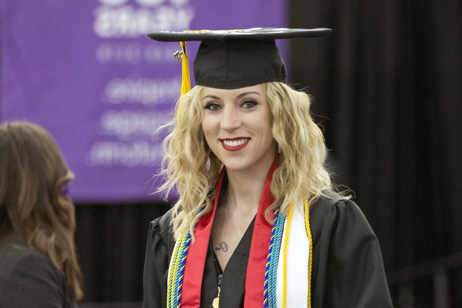 An international student smiles at graduation.