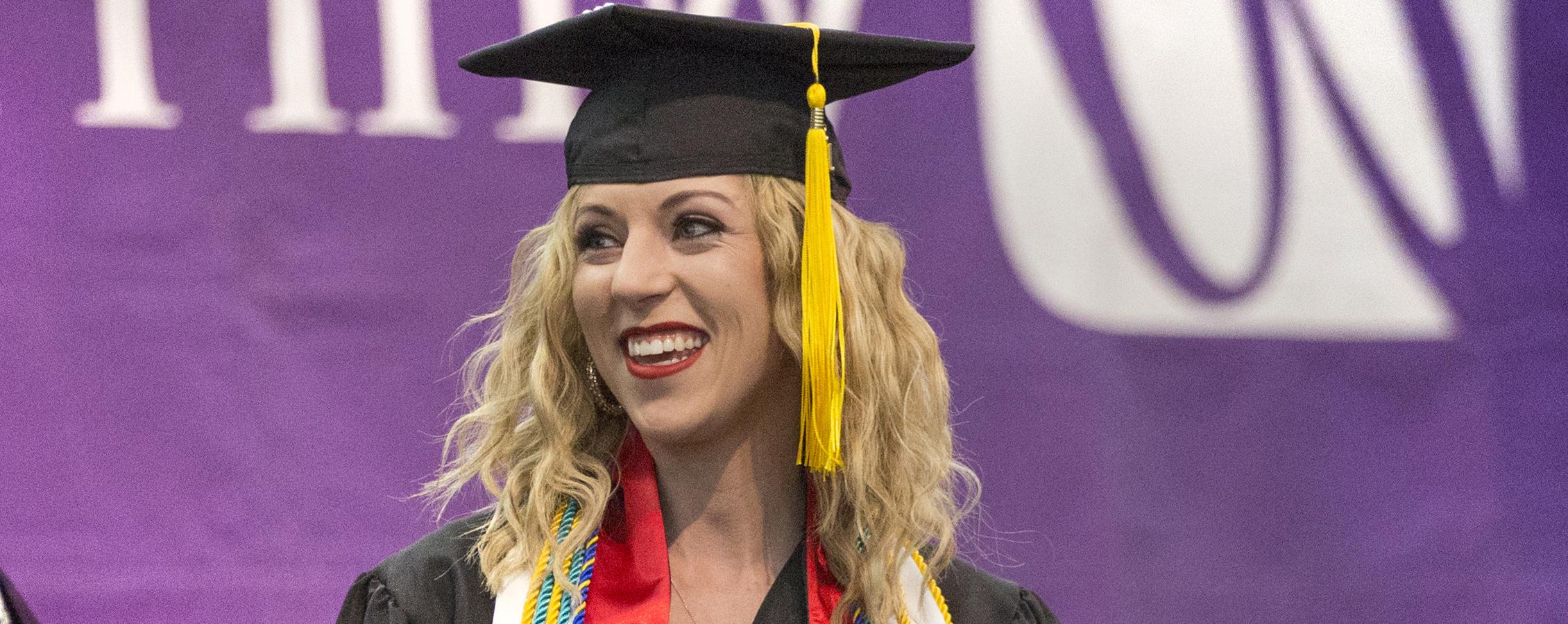 An international student smiles at graduation.