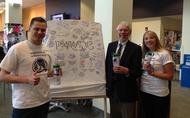 Three people standing in front of a presentation board