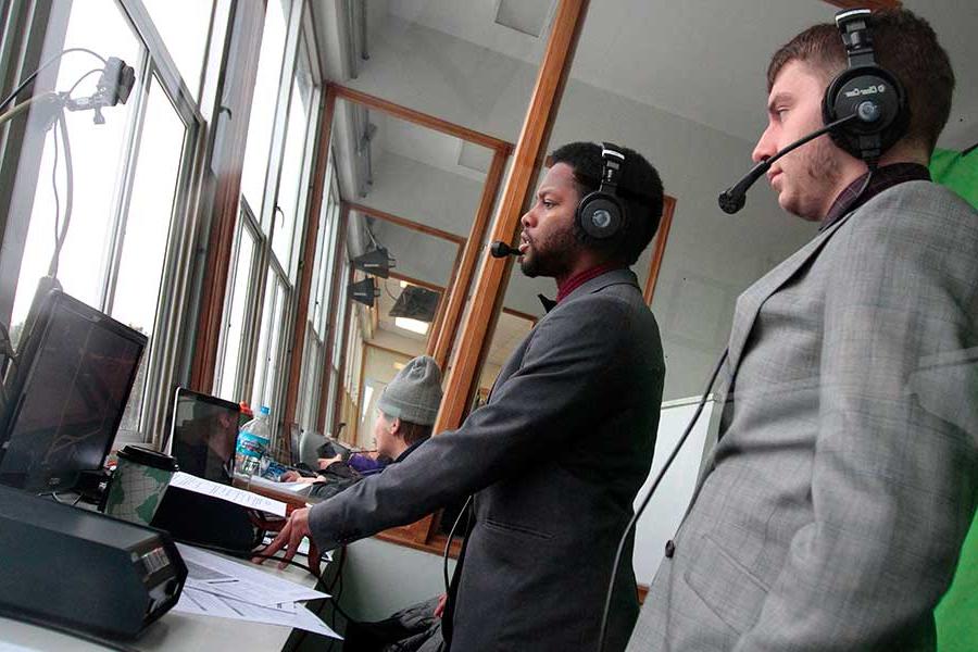 Two students broadcast a football game.