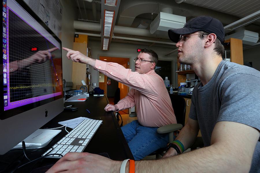 Two people work on a computer.