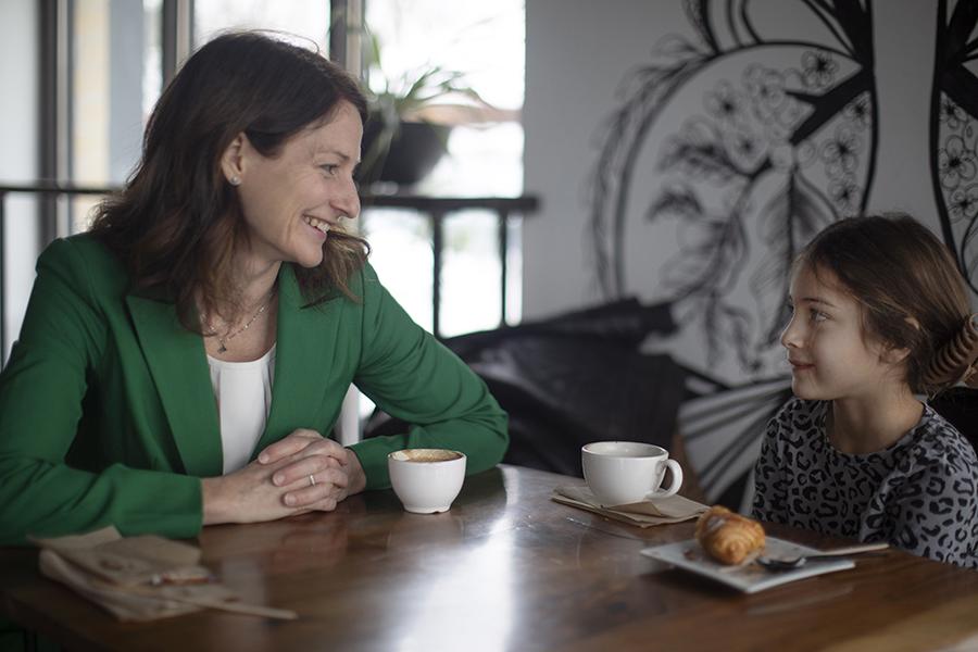 Angela Rachidi looks at her daughter and smiles while they sit at a table.