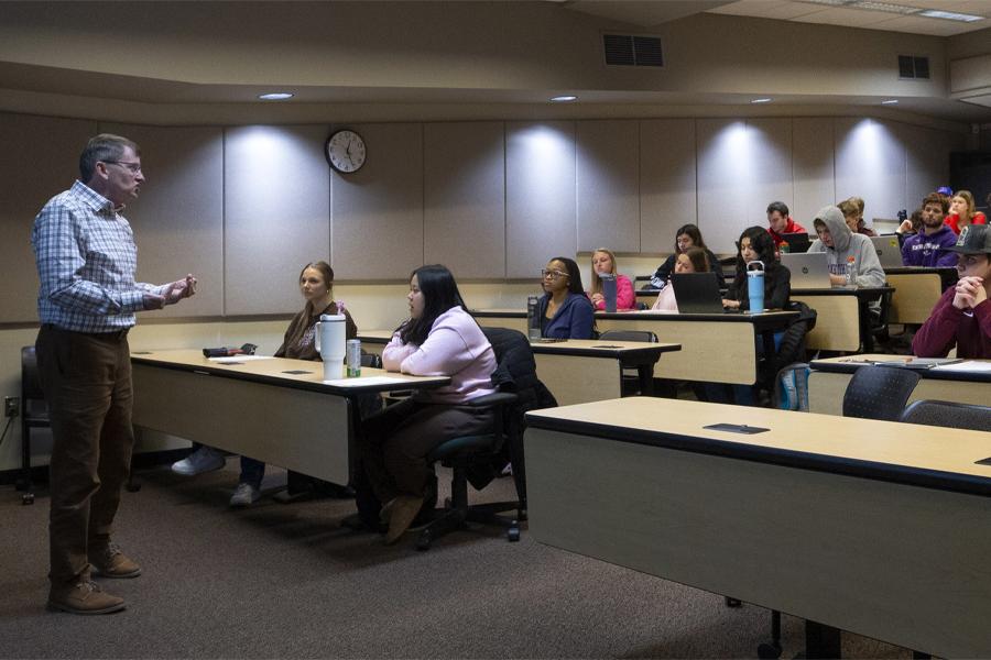 A faculty member teaches at the front of a special education class.